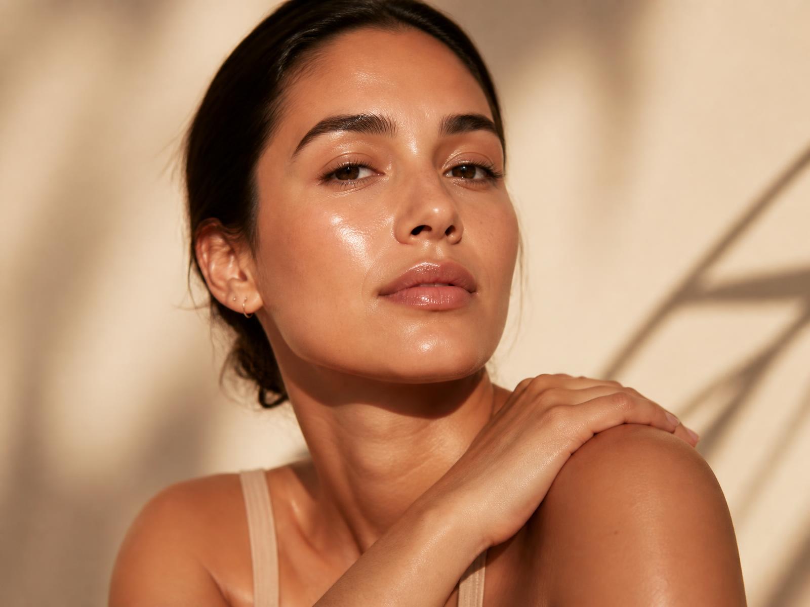 Woman with radiant, glowing skin in warm golden light